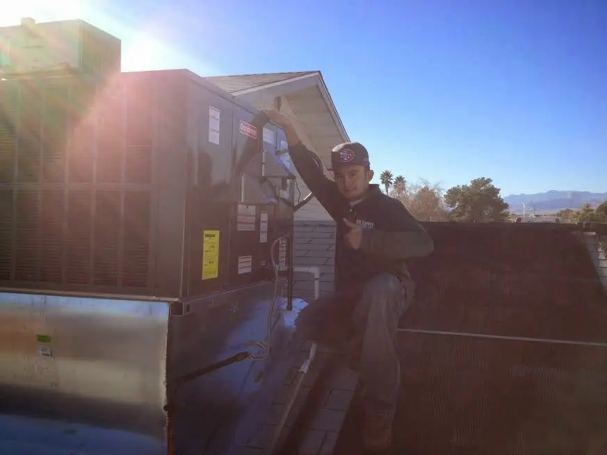 HVAC technician performing Heat Pump Repair on a rooftop unit in Camano