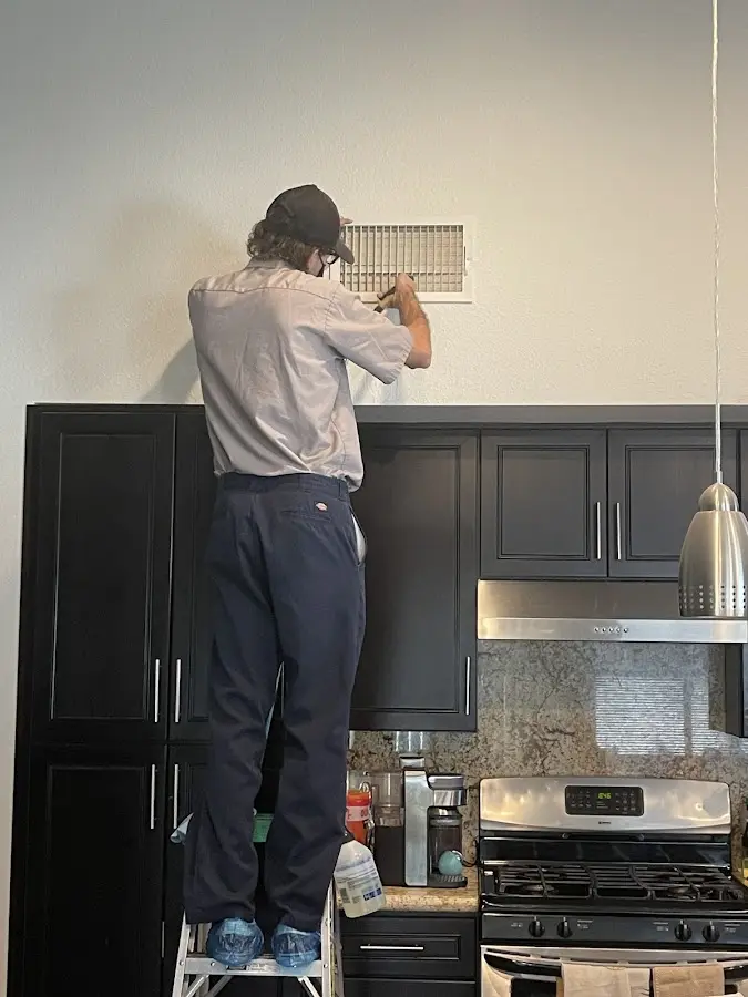 Technician inspecting an air vent during HVAC service in Camano